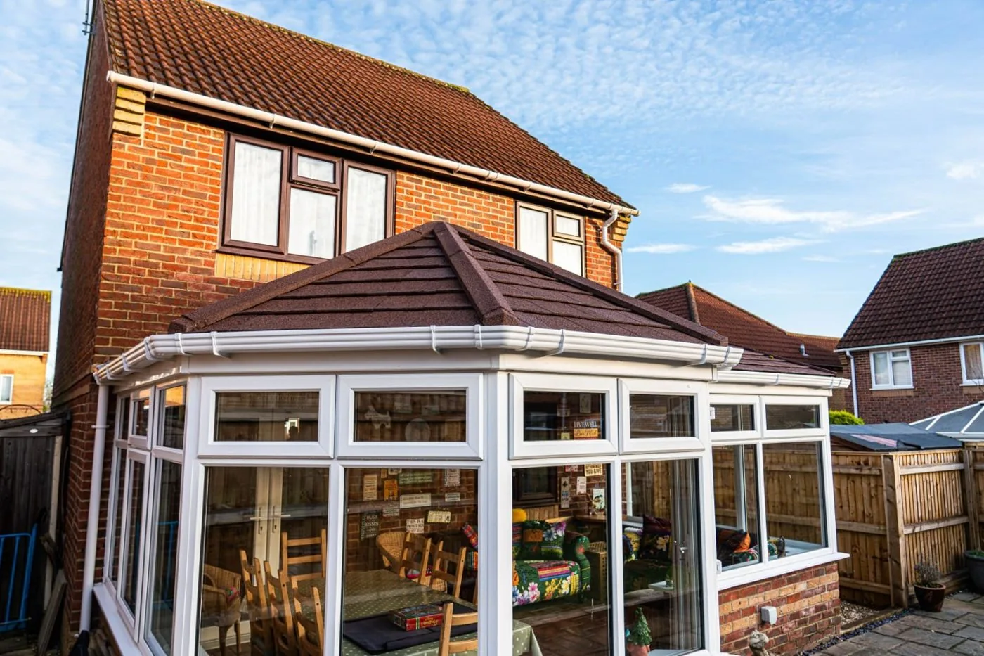 Red-brick house with a grey tiled conservatory roof