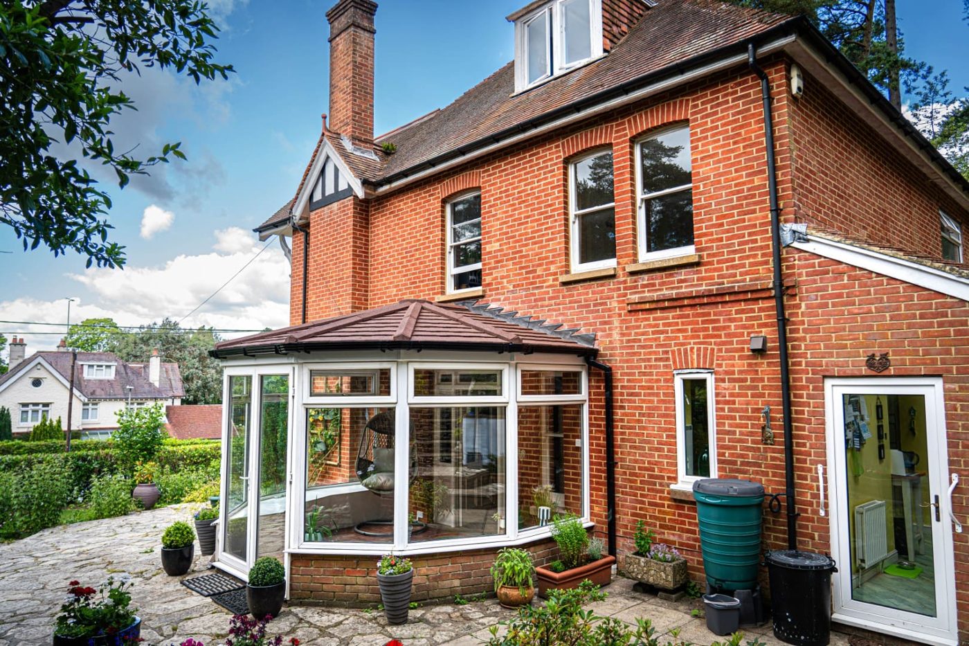 Period red-brick house with a slate-effect tiled conservatory roof
