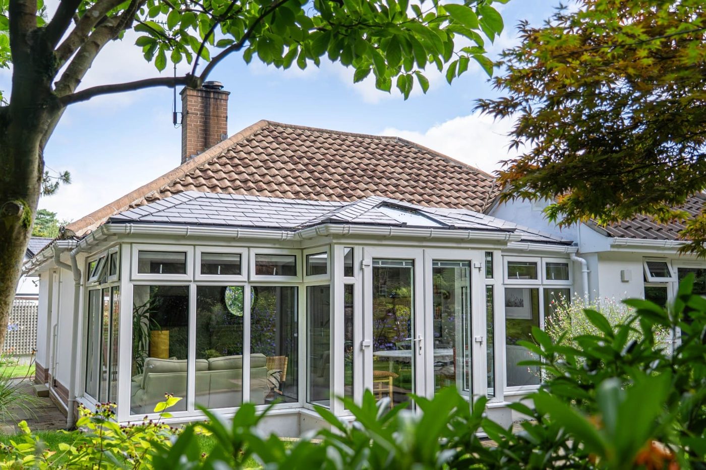 Bungalow conservatory with brown tiles and a roof window