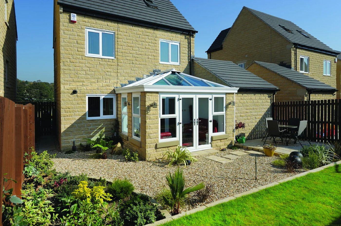 Glass-roof orangery in white on a stone-built house