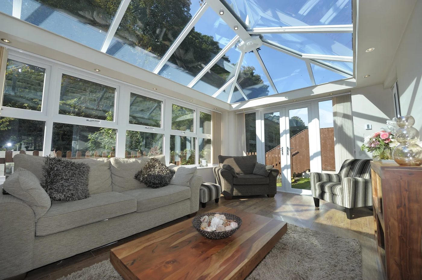 Inside a bright glass-roof conservatory furnished as a living room