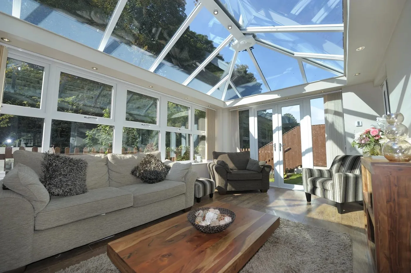 Inside a bright glass-roof conservatory furnished as a living room