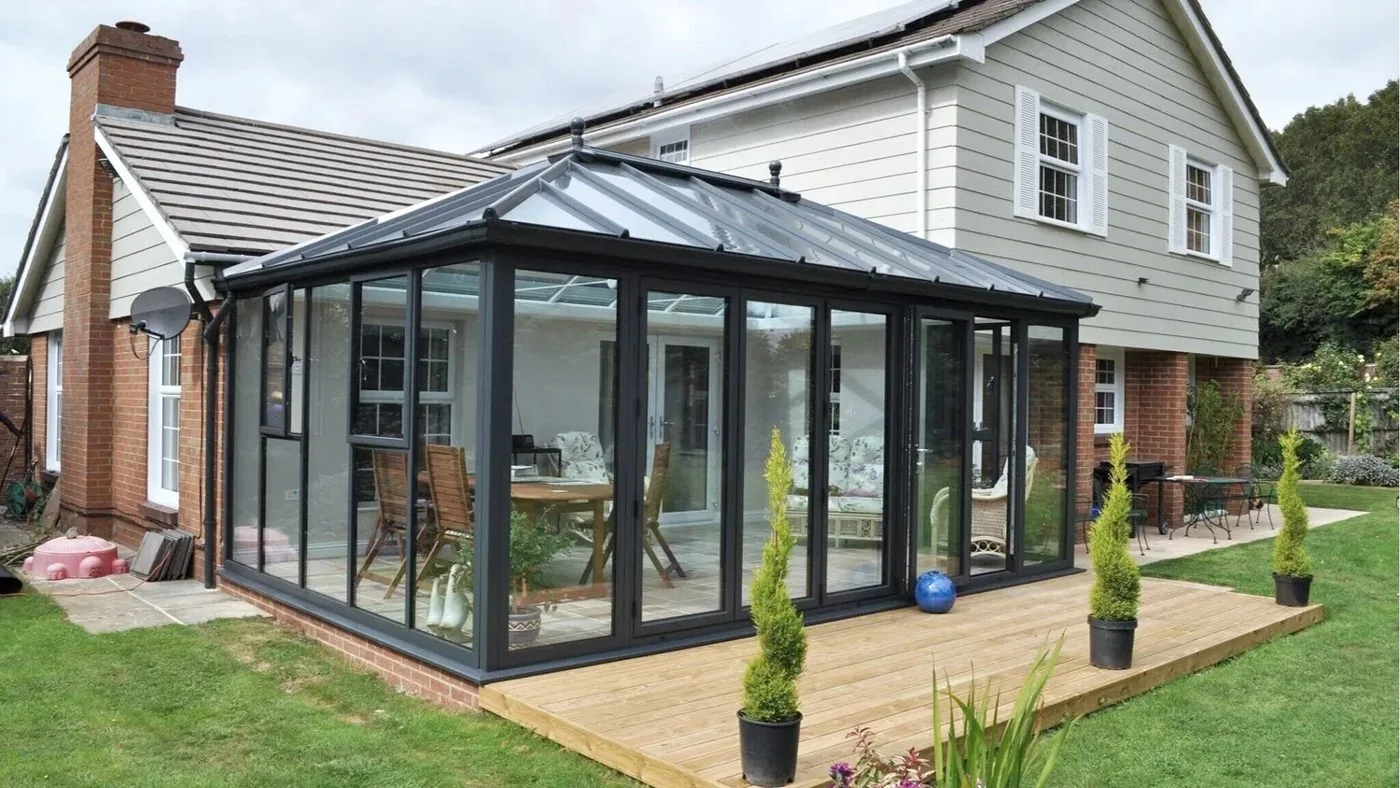 Glass conservatory roof in anthracite grey with matching frames and decking