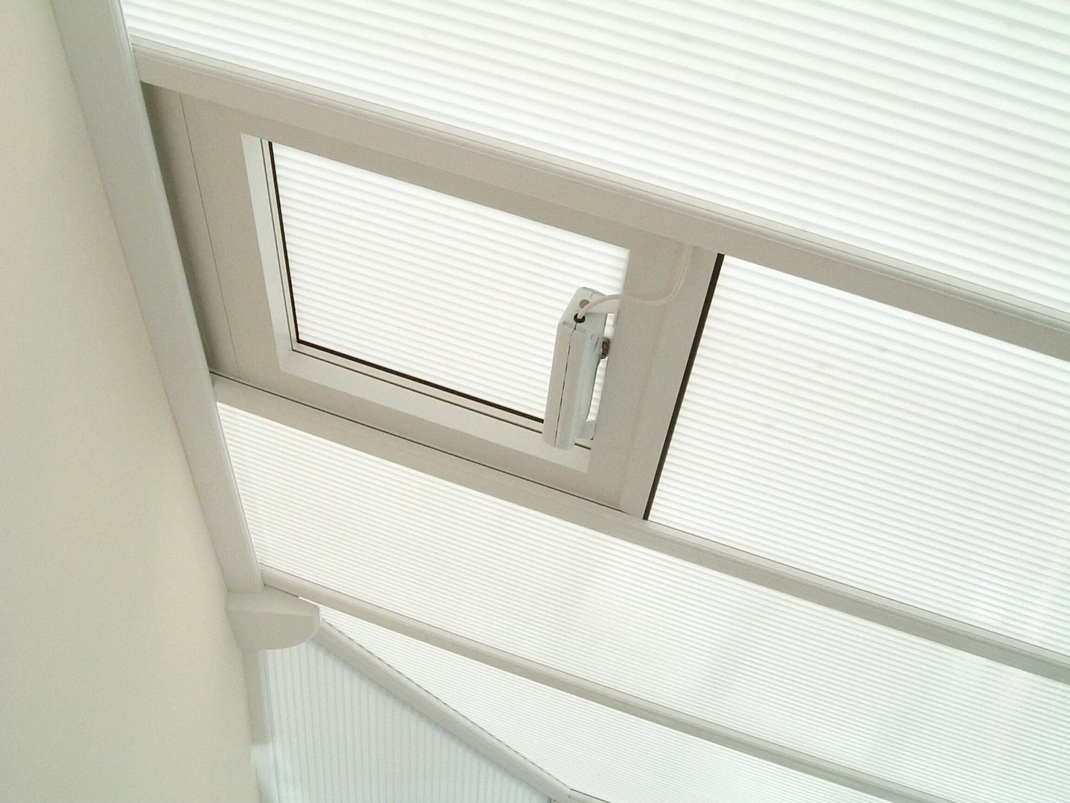 Polycarbonate conservatory roof panels with an opening roof vent, seen from inside