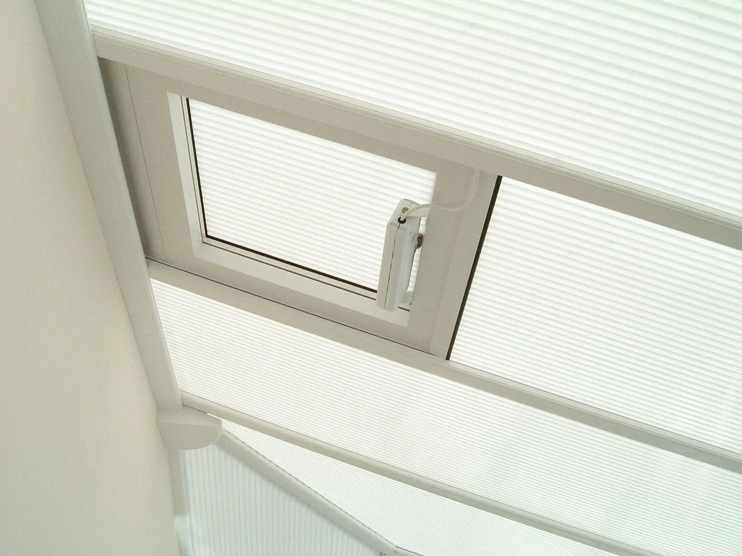 Polycarbonate conservatory roof panels with an opening roof vent, seen from inside